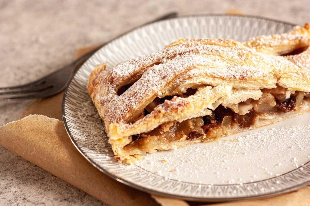 Gebaksbordje met apfelstrudel bestrooid met poedersuiker