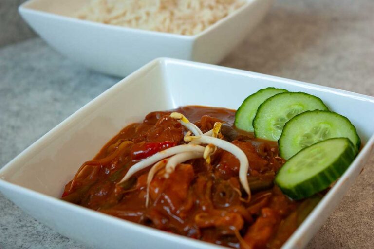 Duvelkesvlees gegarneerd met taugé en plakjes komkommer. Erbij een kom rijst.